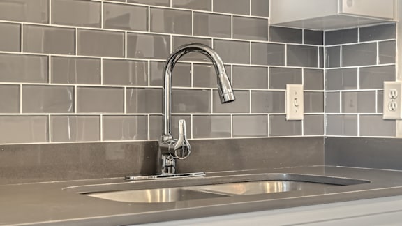 A modern kitchen sink with a chrome faucet.