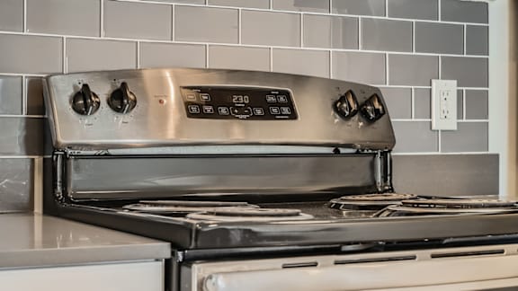 A stainless steel oven with the control panel showing 230 degrees.