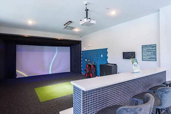 A room with a white counter and a screen on the wall.