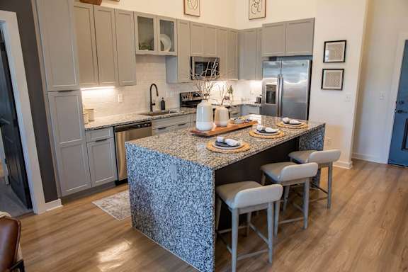 a kitchen with an island and a stainless steel refrigerator