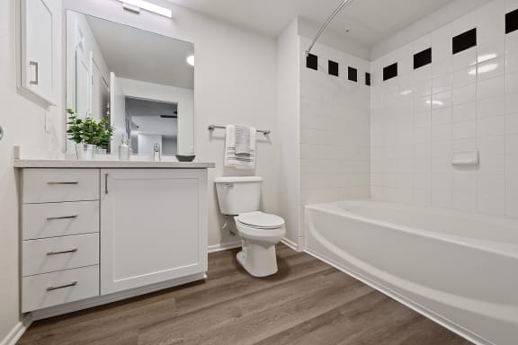 a white bathroom with a toilet and a tub
