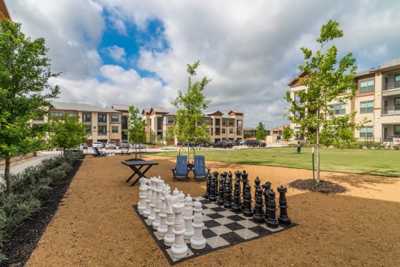 Outdoor games with oversize chess board and pieces at Windsor Lakeyard District, an apartment community in North Dallas