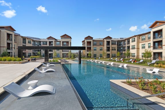 Resort style pool with outdoor seating at Windsor Lakeyard District, an apartment community in North Dallas