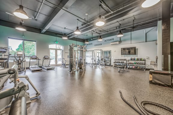 a spacious fitness center with cardio machines and other exercise equipment