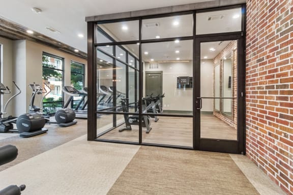 a gym with a brick wall and glass doors