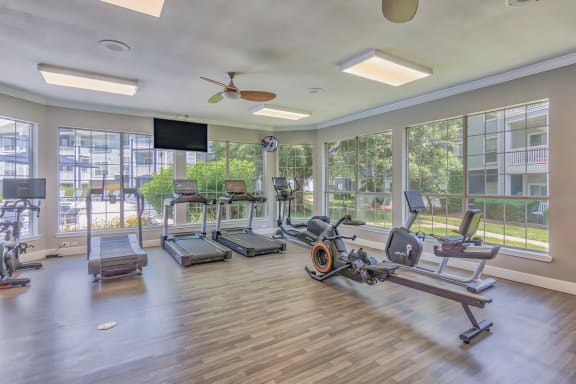 a gym with exercise machines and a flat screen tv