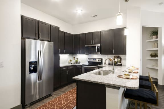 Kitchen with a large island and stainless steel appliances at Windsor Lakeyard District, an apartment community in North Dallas