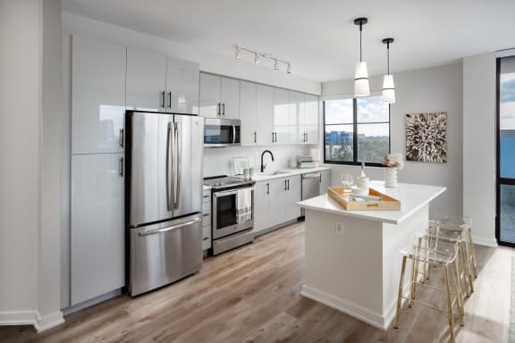 a kitchen with white cabinets and stainless steel appliances
