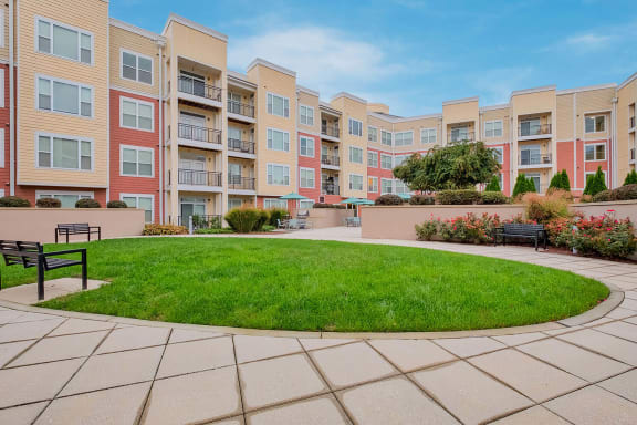 a circle of grass in front of an apartment building
