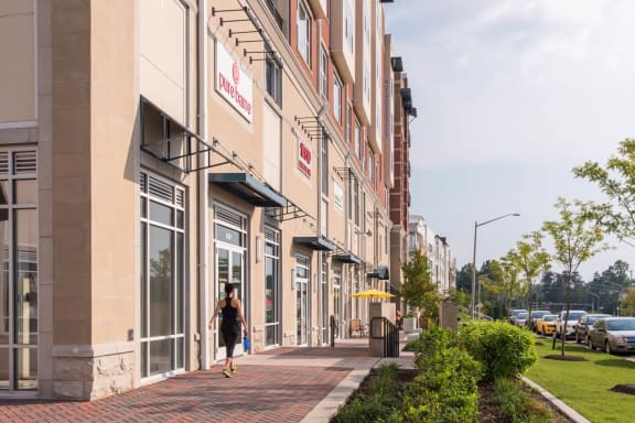 a woman walking down a sidewalk in front of a building