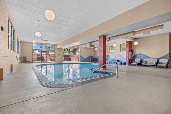 A large indoor swimming pool with a concrete floor and walls.