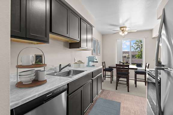 A kitchen with black cabinets and a marble countertop.