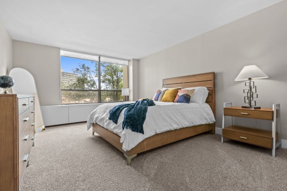 a bedroom with a bed and a large window