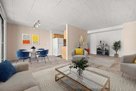 A living room with a glass coffee table and blue chairs.