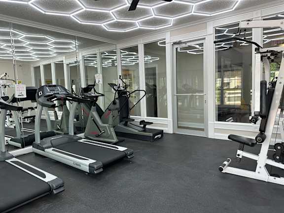 A gym with treadmills, elliptical machines, and other exercise equipment.