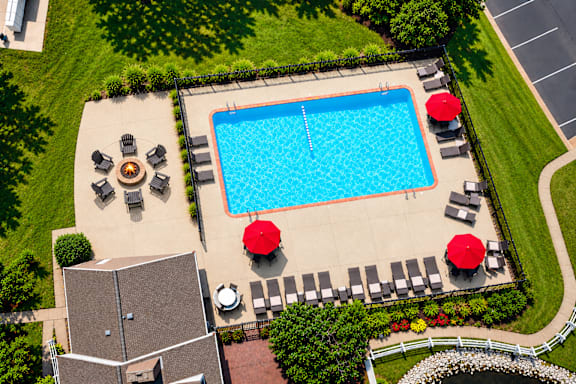 A pool surrounded by chairs and umbrellas.