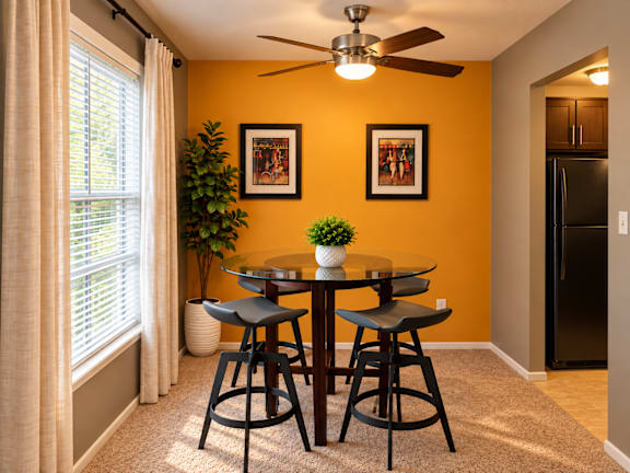 A dining room with a table and chairs.
