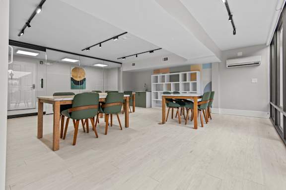 A conference room with a long table and green chairs.