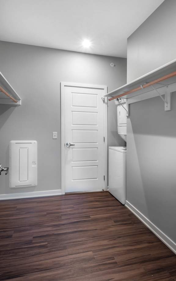A white door is in a room with wood floors and a white wall.