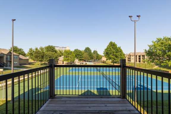 Balcony view of a tennis court from a one-bedroom townhome at The Lakes Model Unit.