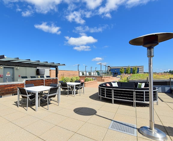 A patio with a table and chairs and a metal pole.