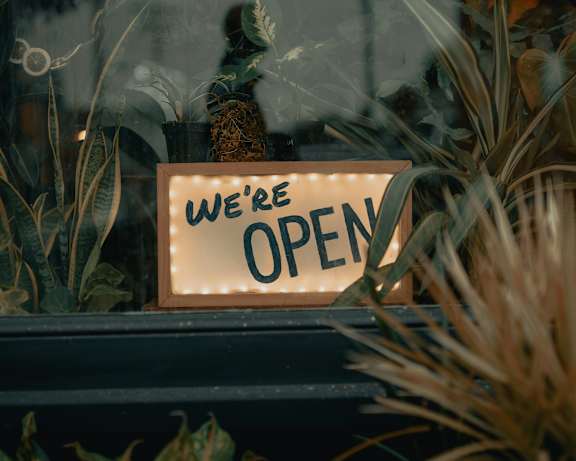A sign in a window that says "We're Open".