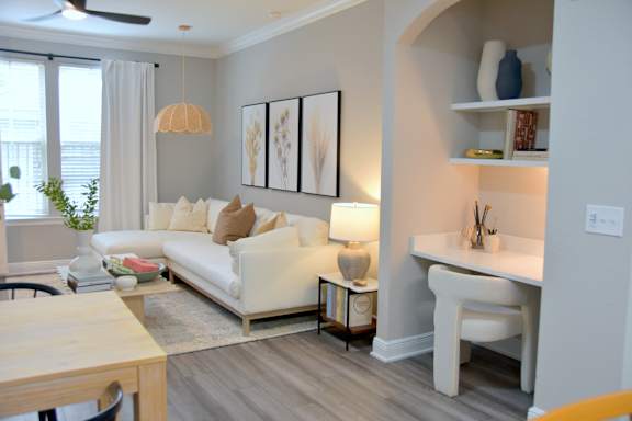 A living room with a white couch and a wooden coffee table.