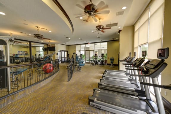 a spacious fitness center with treadmills and exercise balls