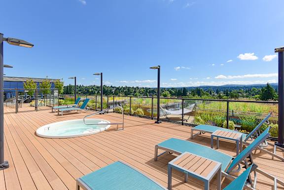a deck with a hot tub and lounge chairs