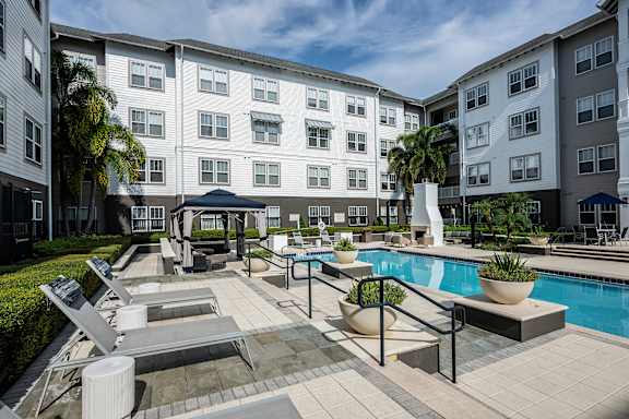 A pool area with a white umbrella and a black railing.