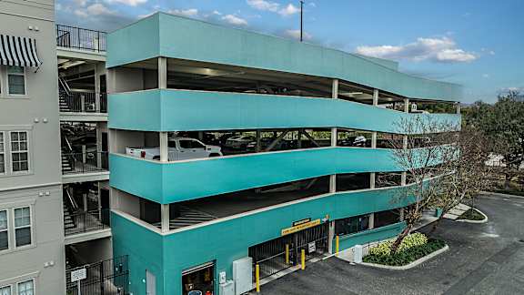 A multi-story parking garage with a blue tinted exterior.