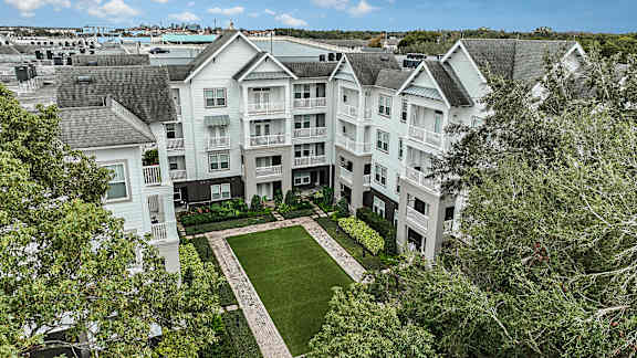 A large white building with a green lawn in front.