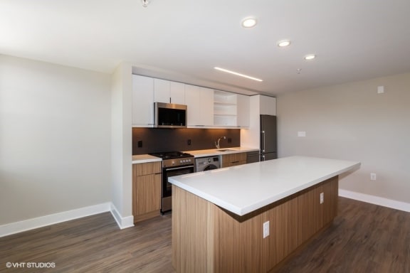 a kitchen with white countertops and wooden cabinets at Carver and Slowe Apartments, Washington, DC
