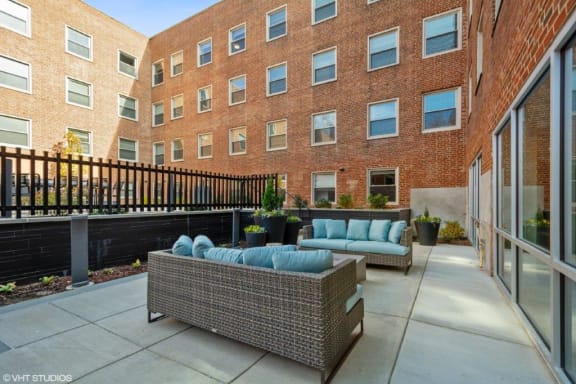 a patio with furniture and a brick building in the background at Carver and Slowe Apartments, Washington, 20001