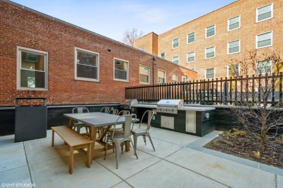 a patio with a table and chairs and a grill at Carver and Slowe Apartments, Washington, DC
