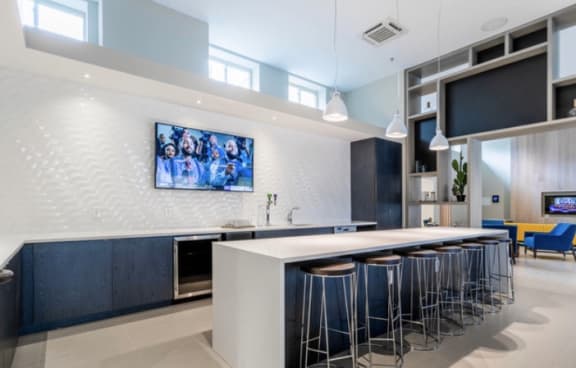 a kitchen with a long island with a white countertop and blue stools at Carver and Slowe Apartments, Washington, DC