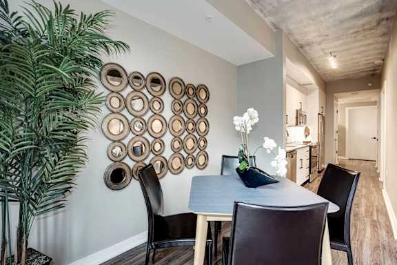 a dining room with a table and chairs and a plant at Coda on H Apartments, District of Columbia