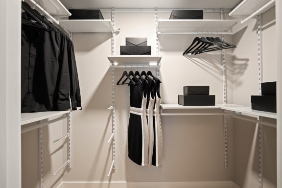 a walk in wardrobe with white shelves and rails at Tribeca, Washington
