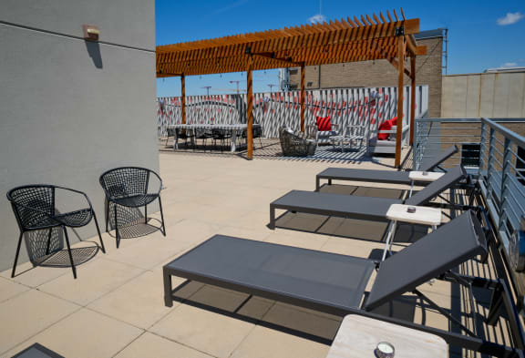 a rooftop patio with tables and chairs and a pergola at 3333 Wisconsin, Washington