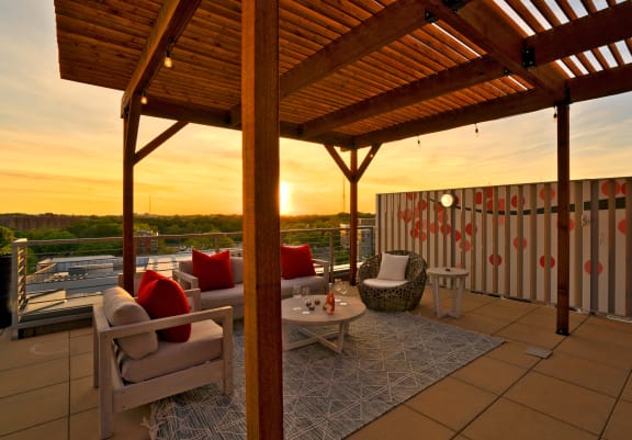 a roof deck with a pergola and couches