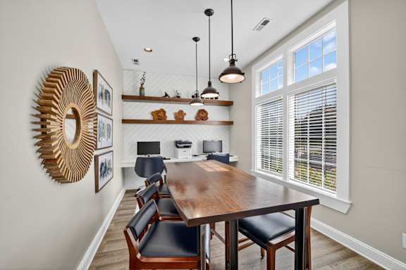 A dining room with a wooden table and chairs.