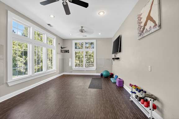 A room with a Nike logo on the wall and a fan on the ceiling.