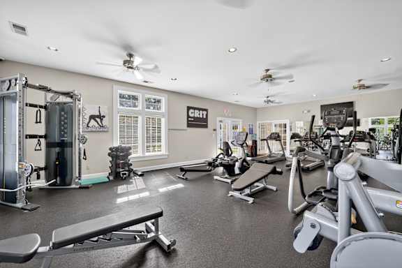 A gym with a variety of equipment including a bench press, leg press, and a squat rack.