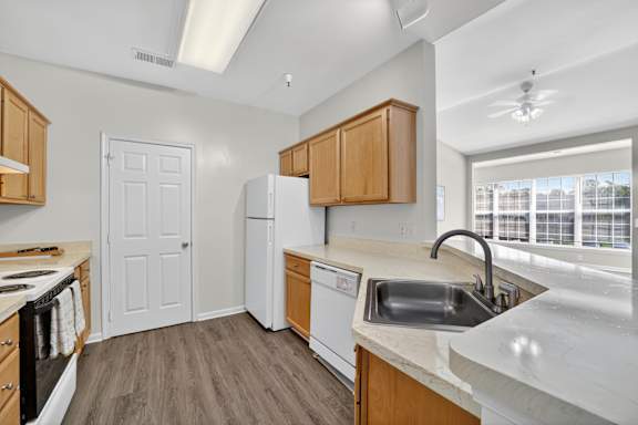 A kitchen with wooden cabinets and a white door.