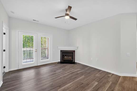 A room with a fireplace and a ceiling fan.