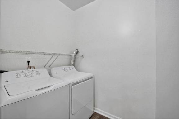 A white washing machine and dryer in a small laundry room.