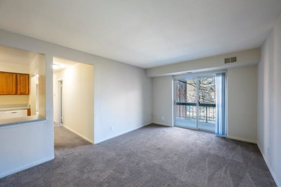 an empty living room with a door to a balcony