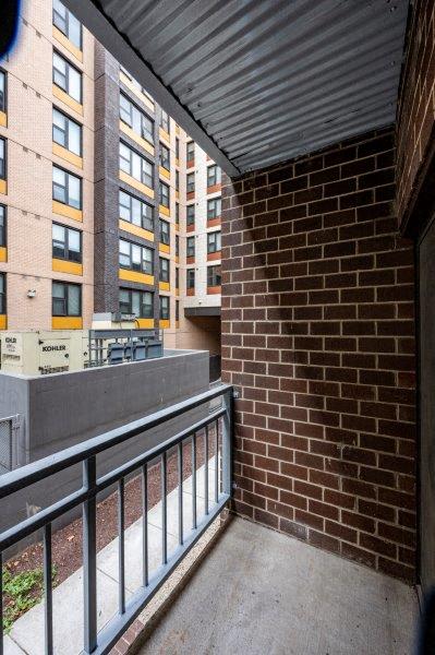 a balcony with a brick wall and some buildings