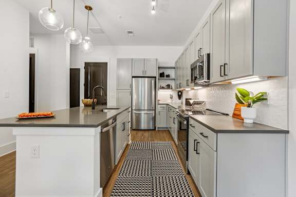 A modern kitchen with stainless steel appliances and white cabinets.