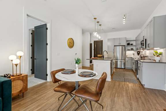 A modern kitchen with a dining table set for two.